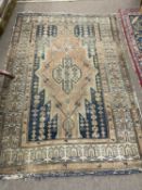 An antique Middle Eastern wool floor rug decorated with a large central lozenge on a principally