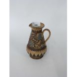 19th Century Doulton Lambeth jug, the buff body with an applied brown and green florets, 15cm high