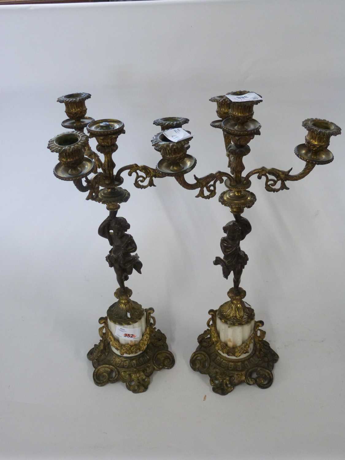 Pair of candelabra in French Empire style the four branch candelabra supported by a bronzed cherub