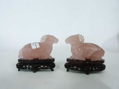 Pair of pink jade rams on wooden bases, 9cm long