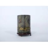 Small Chinese metal cylindrical pot with ribbed design and Chinese faces on a wooden base, 5cm high