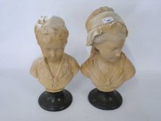 Pair of ceramic busts of children on black circular bases, 42cm high