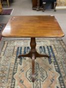 Late Georgian mahogany tilt top table, the rectangular top raised on a turned column with tripod