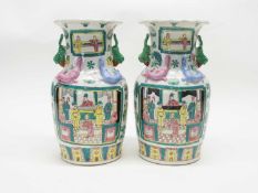 A pair of Chinese vases with polychrome designs of panels of Chinese figures surrounded by