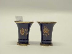 A small pair of KPM vases of flared form, the blue ground with gilt floral decoration, 8cm high