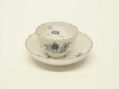 A Lowestoft porcelain fluted tea bowl and saucer decorated with floral sprays within an unusual