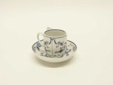 A Lowestoft porcelain tea cup and saucer decorated in underglaze blue with a Meissen style