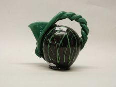 An unusual pottery ewer with rope effect handle, the body with striped green decoration on black
