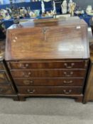 A Georgian mahogany bureau of typical form, the full front opening to an interior with small drawers