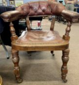 A 19th Century Library leather armchair upholstered with broad seat and raised on turned legs