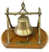 An early 20th Century Aesthetic Movement-style table bell, the cast brass bell suspended from a