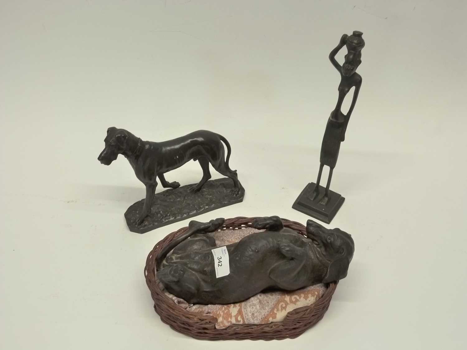 Group of resin models of dogs, one in a basket by Hereditaries Ltd together with a further metal
