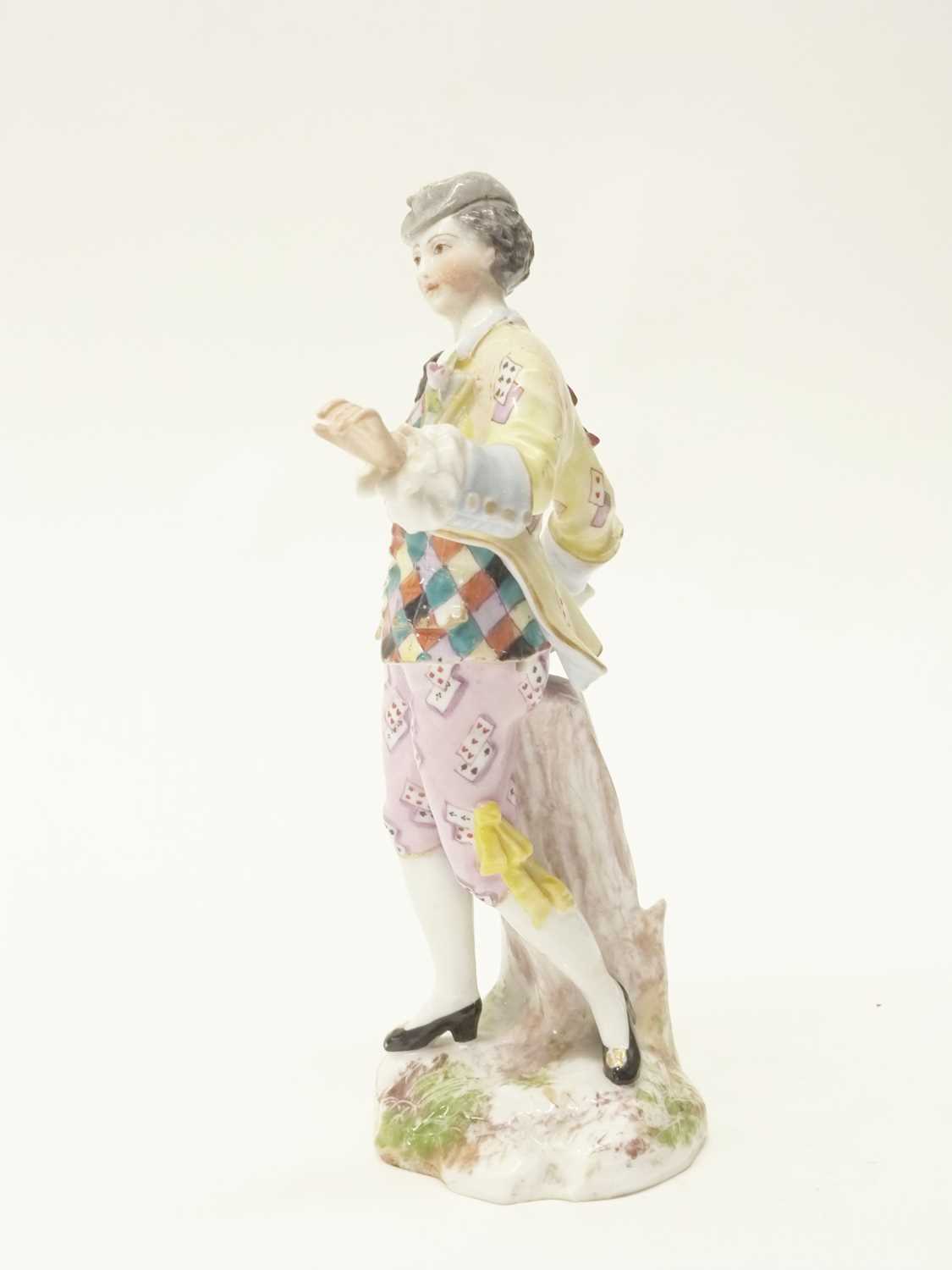 A continental porcelain figure of a gentleman depicting harlequin, cross swords and E mark in blue - Image 2 of 2