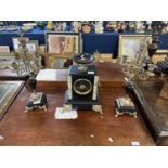 A French clock garniture, the black slate and marble clock with urn formed mount, lions head