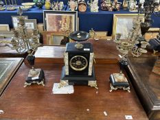 A French clock garniture, the black slate and marble clock with urn formed mount, lions head