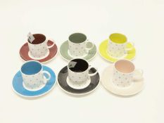 A Susie Cooper 1950's set of six coffee cans and saucers with a sprigged design and coloured