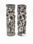 Two large carved wooden candlesticks, carved with tribal type figures, 30cm high