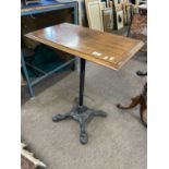Small side table with rectangular hardwood top over a cast iron four footed base, 60cm wide