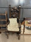 A Victorian dark gothic oak throne type chair with pierced foliate carved back with mask centre,