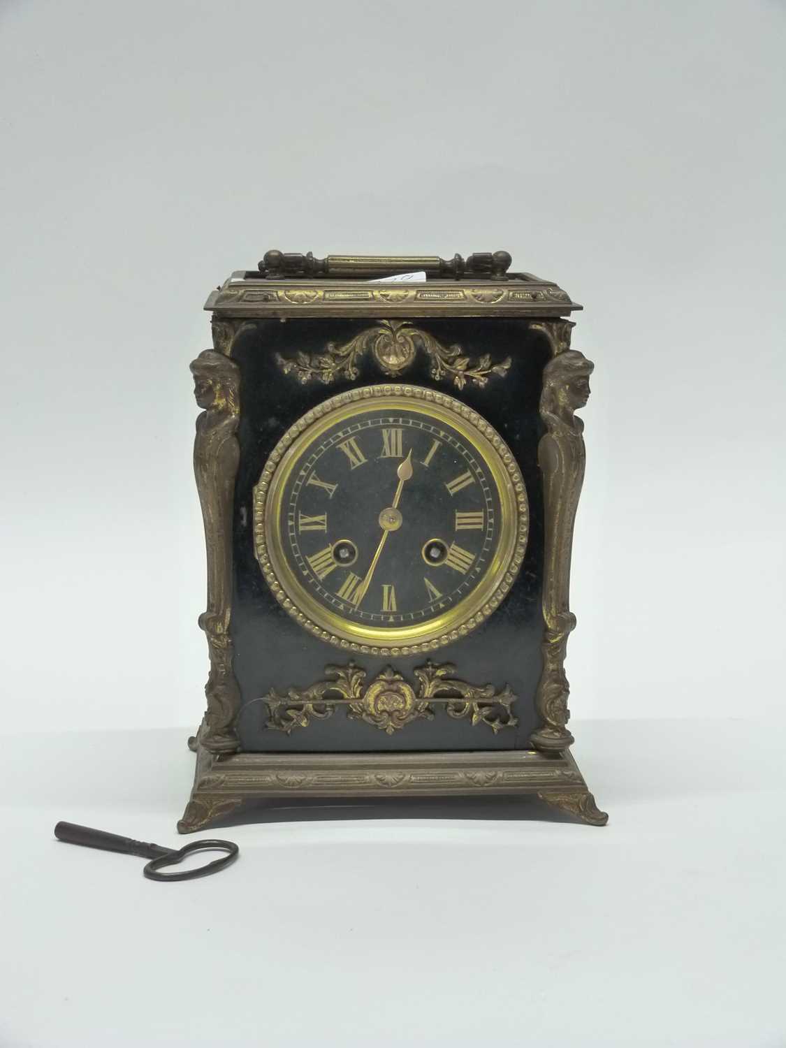 A 19th Century brass mantel clock, black ebonised wood with gilt brass decoration, 23cm high (with