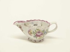 A Bow porcelain cream boat with a polychrome design of flowers beneath a shaped rim, 14cm long