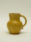 A pottery jug by Edwin Beere Fishley of Framington, North Devon, the yellow ground inscribed "