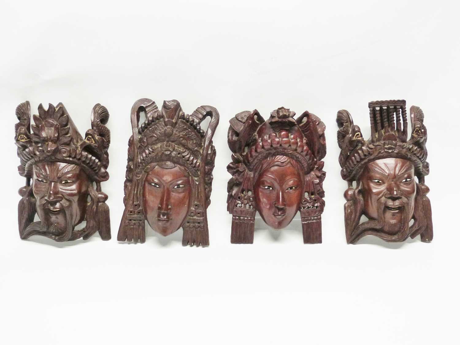 Group of four wooden carved masks, probably Balinese of various deitys