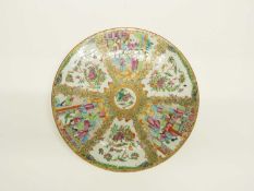 A large Canton charger decorated with polychrome design of Chinese figures and panels of flowers