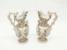 Two late 19th Century continental porcelain ewers decorated with panels of flowers bordered by