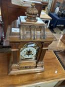 A late 19th Century mantel clock set in an architectural carved wooden case, fitted with a brass