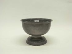 A hammered pewter bowl in Liberty style, raised on circular foot, 23cm diameter