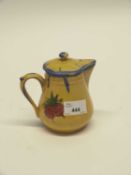 A French pottery jug and cover, the yellow ground with floral decoration