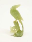 Jade model of a bird on a rock with carved flowers beneath, 12cm high