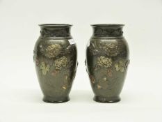 A pair of Japanese bronze vases Meiji period decorated in relief with a floral design with birds,
