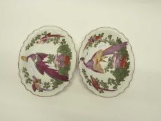 A pair of Chelsea porcelain shaped dishes decorated with exotic birds amongst flowers and standing
