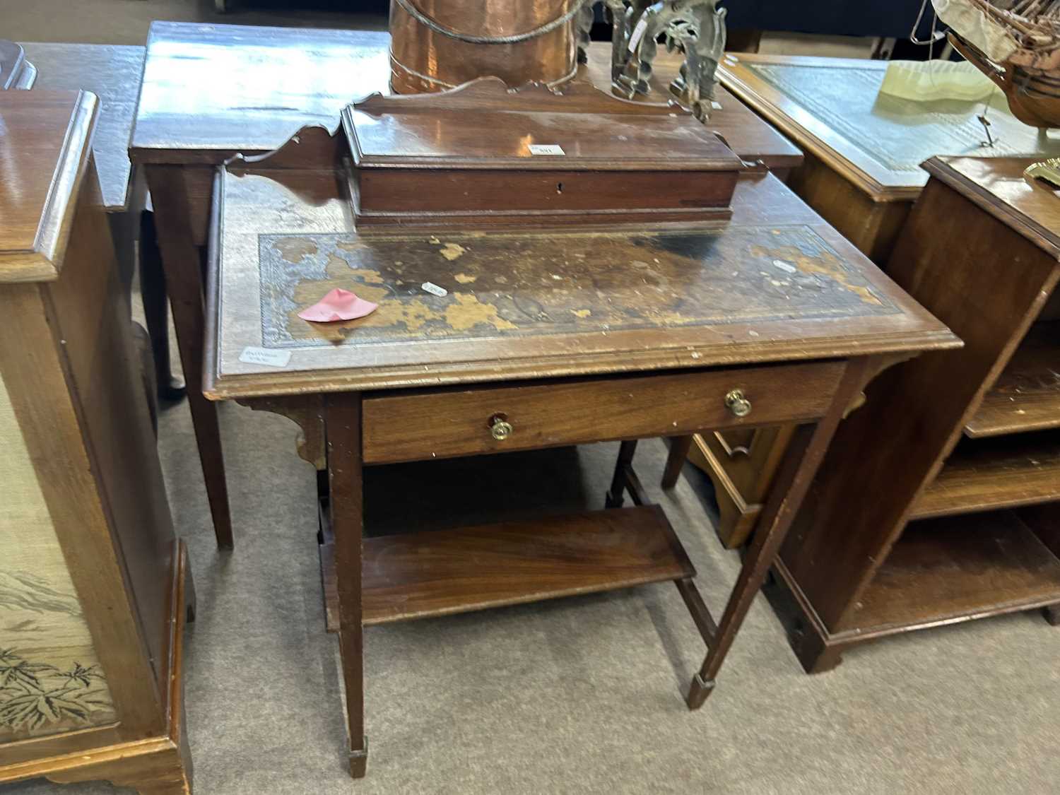 A small Edwardian writing table with a hinged storage compartment, worn leather writing surface