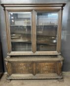 A large 19th Century continental oak side cabinet formed of two sections, the top section with two