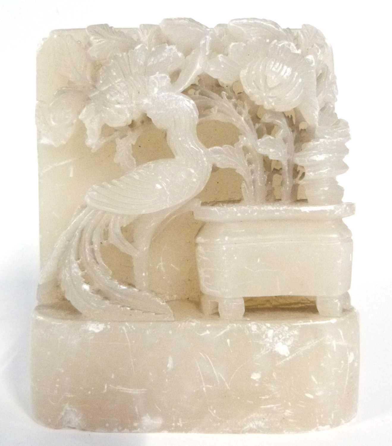 A rectangular soap stone block carved in relief with birds and flowers, 16cm high