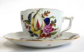 A large Herend cup and saucer decorated in Meissen style with sliced fruit and flowers, the saucer