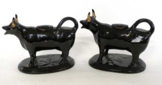 A pair of Jack Field type black and gilt cow creamers