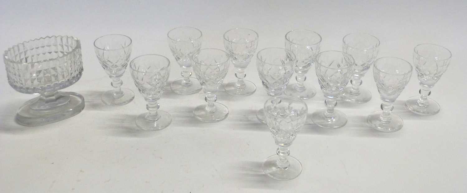 A small cut glass hobnail cut condiment glass and twelve small spirit glasses