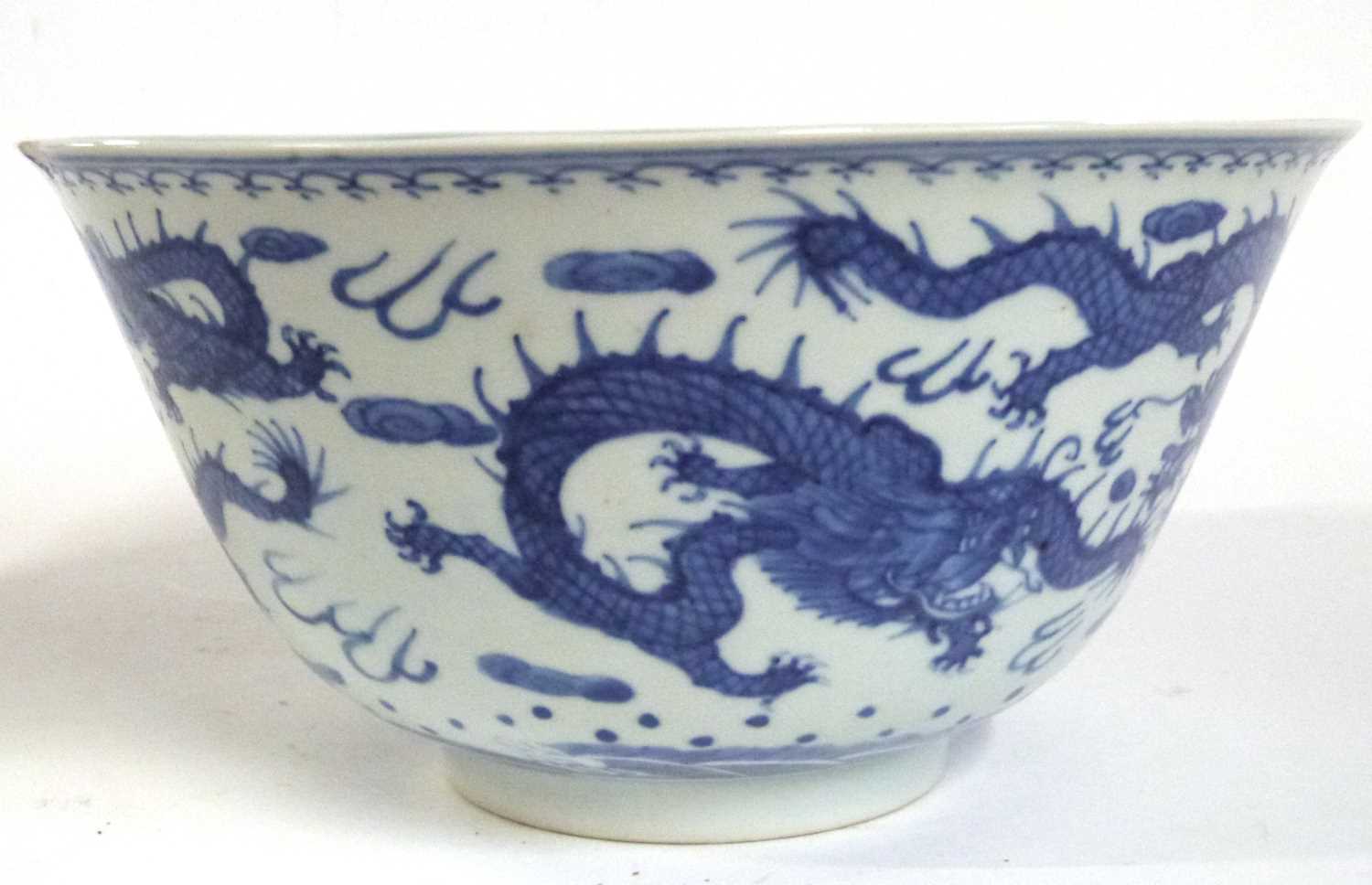 A Chinese porcelain bowl with everted rim, blue and white decorations of dragons chasing the flaming