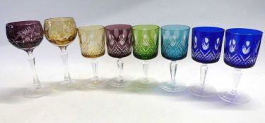 A group of eight various coloured glass wine glasses and beakers decorated in Bohemian style