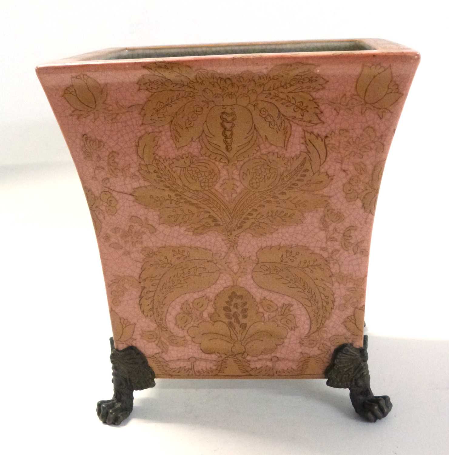 A continental porcelain jardiniere raised on four gilt scroll feet, the pink ground with floral