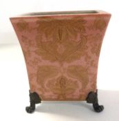 A continental porcelain jardiniere raised on four gilt scroll feet, the pink ground with floral