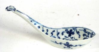 An 18th Century Worcester rice spoon with blue and white design and flower head finial