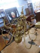 A large reproduction Dutch style brass light fitting, fitted with twelve scrolled arms, approx
