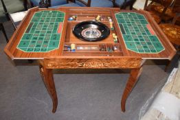 A 20th Century games compendium table with central roulette wheel and reversible top together with a