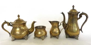 A brass teapot, coffee pot, milk jug and sugar bowl all raised on four stub feet with chased