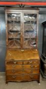 A Georgian mahogany bureau bookcase cabinet, the top section with arched pediment and two glazed